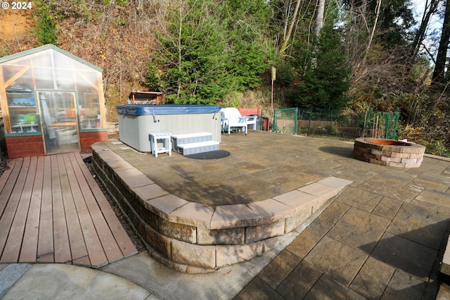 exterior space featuring a fire pit, an outbuilding, and a hot tub