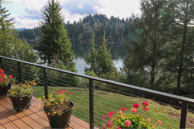 deck featuring a water view and a lawn