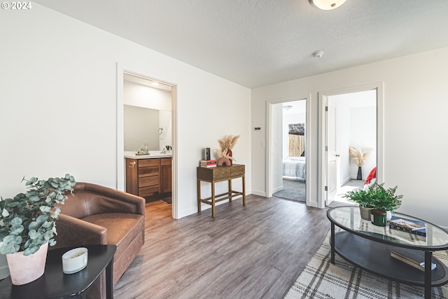 living area with a textured ceiling and hardwood / wood-style floors