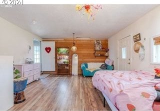 bedroom with wood-type flooring, multiple windows, and wood walls