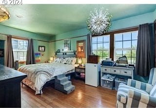 bedroom with a notable chandelier and hardwood / wood-style flooring