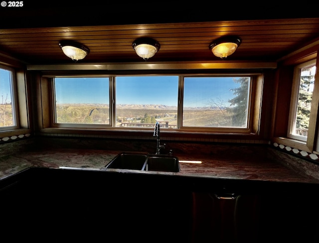 kitchen with sink, dark stone counters, and wood ceiling