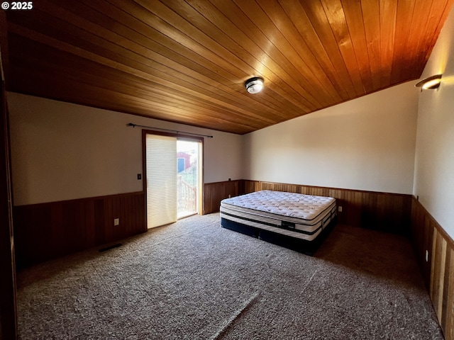 unfurnished bedroom with dark carpet and wooden ceiling