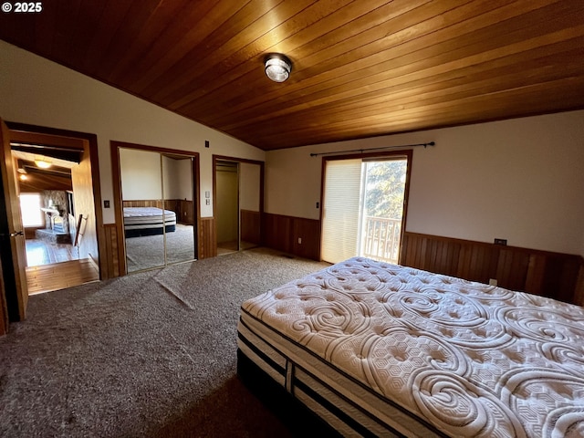 bedroom featuring vaulted ceiling, wooden walls, carpet flooring, multiple closets, and wood ceiling