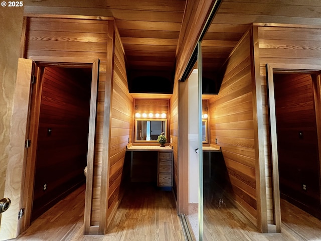 hall featuring wooden ceiling, wood finished floors, and wood walls