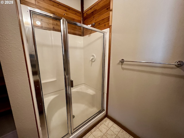 full bath with tile patterned floors, baseboards, and a shower stall