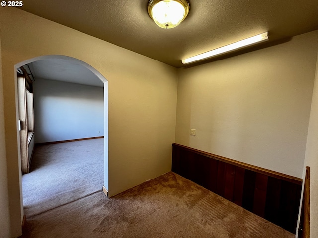 carpeted spare room featuring a textured ceiling