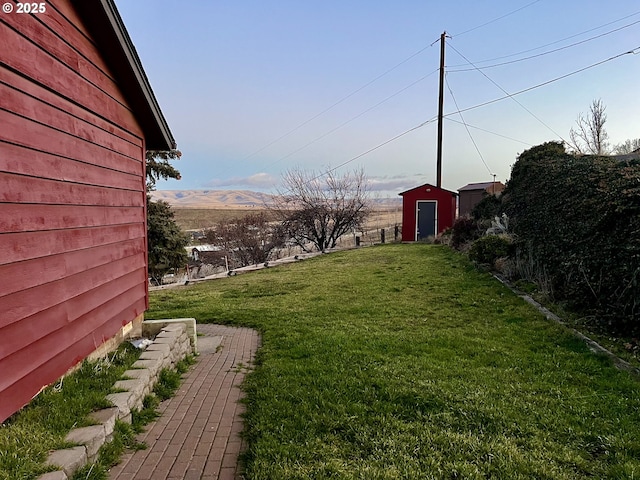 view of yard featuring a mountain view and a shed