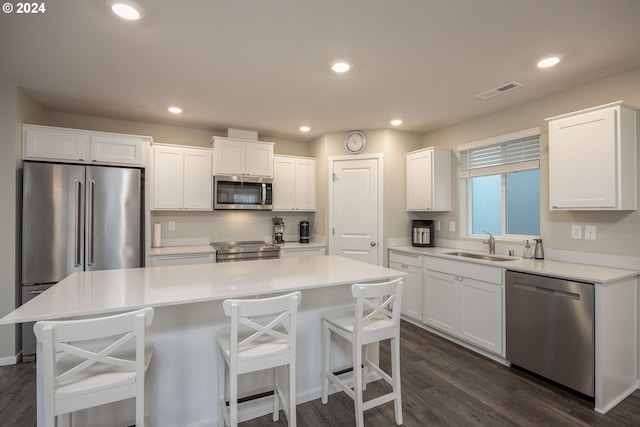 kitchen featuring white cabinetry, a center island, dark hardwood / wood-style floors, and appliances with stainless steel finishes