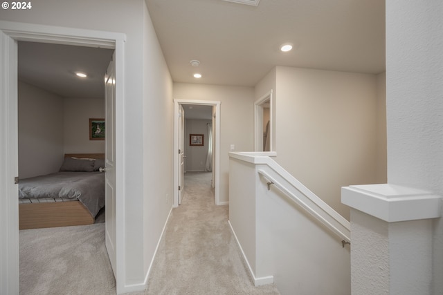 hall with light colored carpet