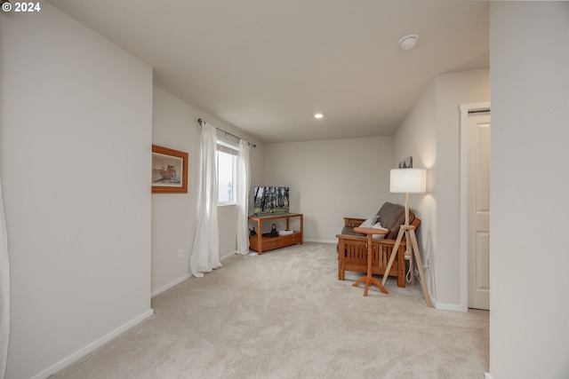 sitting room featuring light colored carpet