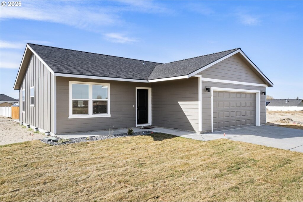 single story home with a front yard and a garage