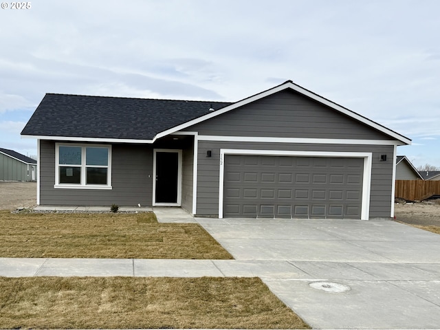 single story home featuring a garage, concrete driveway, a shingled roof, and fence