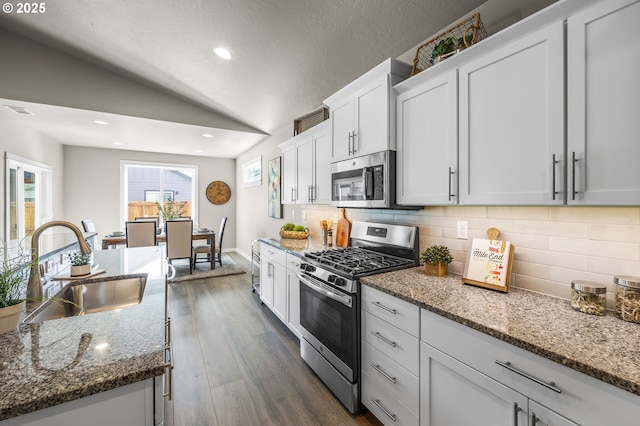 kitchen with decorative backsplash, dark stone countertops, sink, and appliances with stainless steel finishes