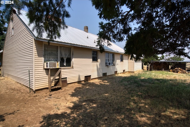 back of house featuring cooling unit and a lawn