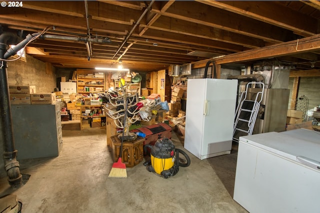 basement featuring fridge and white refrigerator