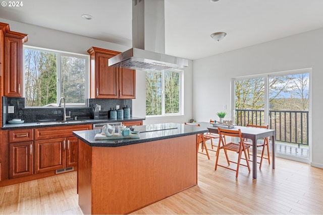 kitchen with a center island, sink, island exhaust hood, and a wealth of natural light