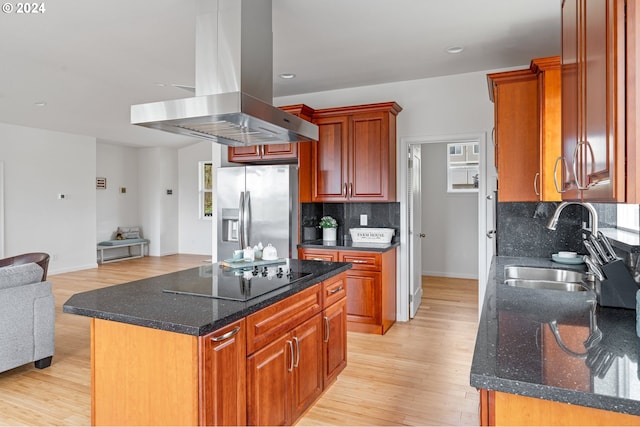 kitchen featuring island exhaust hood, stainless steel fridge, sink, a center island, and light hardwood / wood-style floors