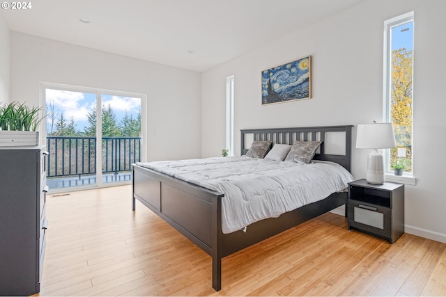 bedroom featuring access to outside, multiple windows, and light hardwood / wood-style floors