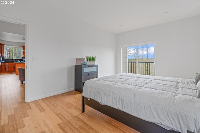 bedroom featuring access to exterior and light hardwood / wood-style floors