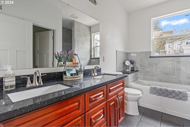 full bathroom with tile patterned floors, vanity, tiled shower / bath combo, and toilet