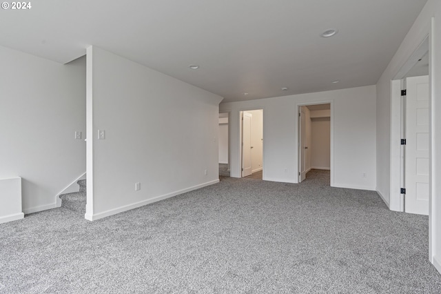 unfurnished bedroom featuring a spacious closet and light colored carpet