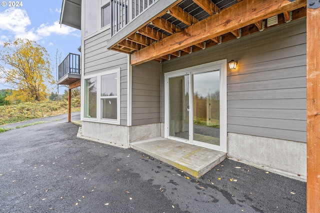 property entrance with a patio area and a balcony