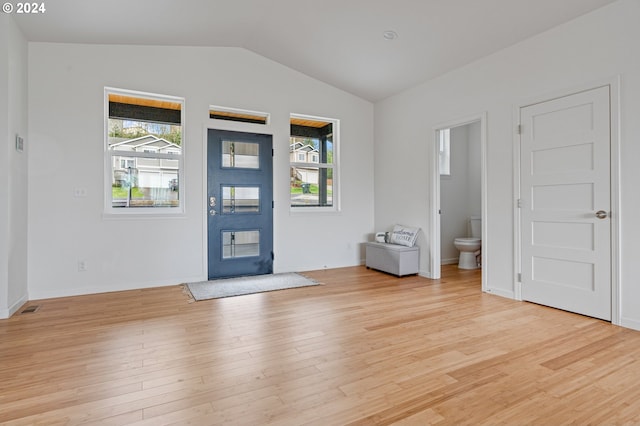 foyer featuring plenty of natural light, light wood-type flooring, and lofted ceiling