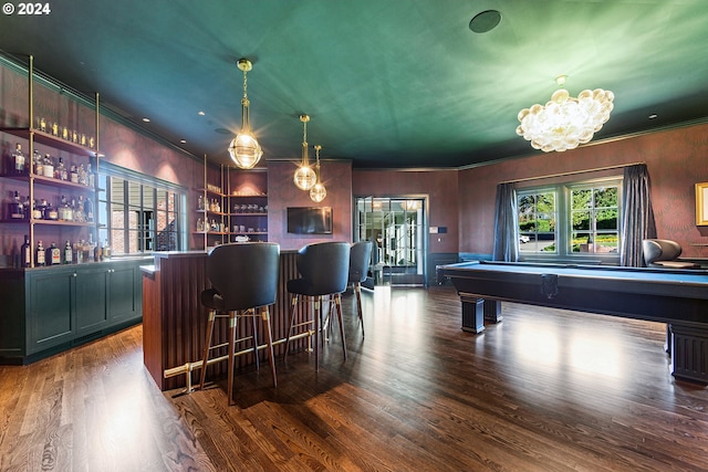 bar with built in shelves, pool table, hanging light fixtures, dark hardwood / wood-style floors, and ornamental molding