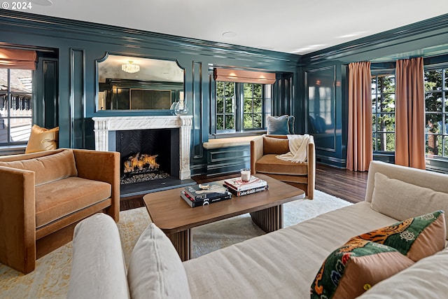 living room featuring a fireplace, wood-type flooring, and crown molding