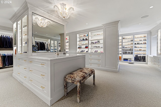 walk in closet with light carpet and an inviting chandelier