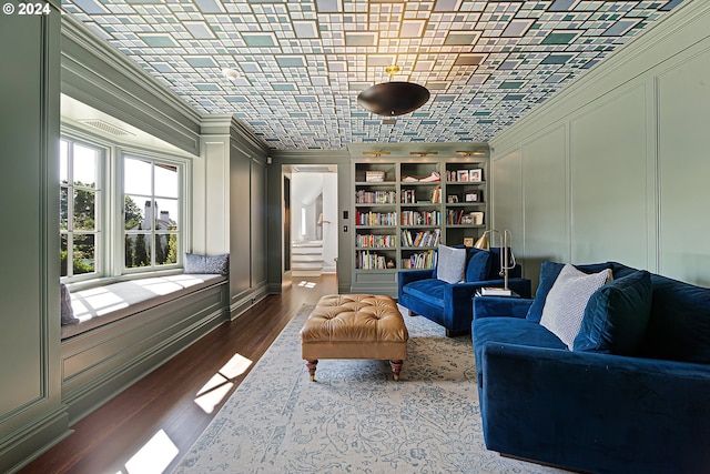 sitting room with hardwood / wood-style floors, built in features, and ornamental molding