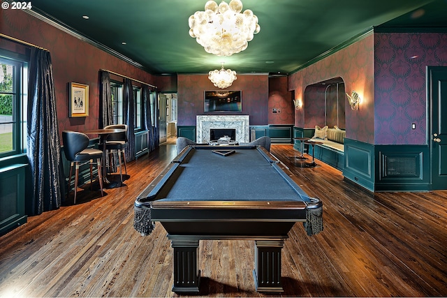 playroom with dark hardwood / wood-style floors, crown molding, pool table, and an inviting chandelier