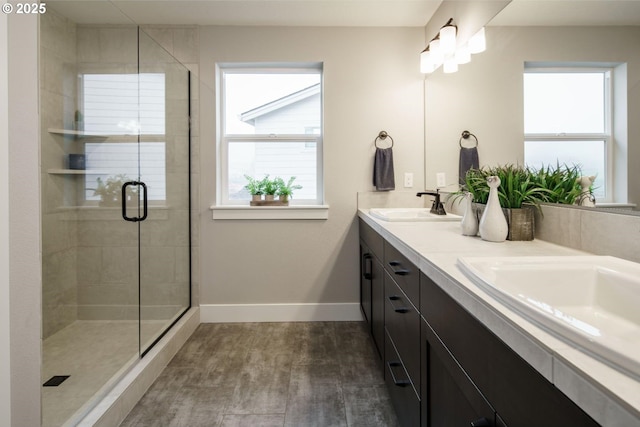 bathroom featuring a shower with shower door and vanity