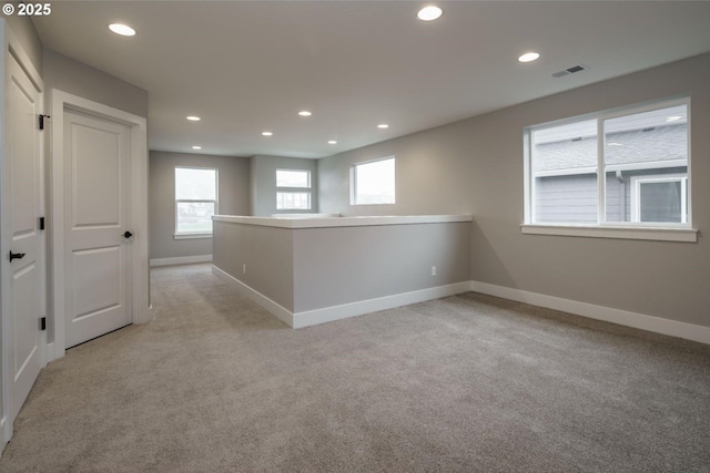 unfurnished room featuring light colored carpet