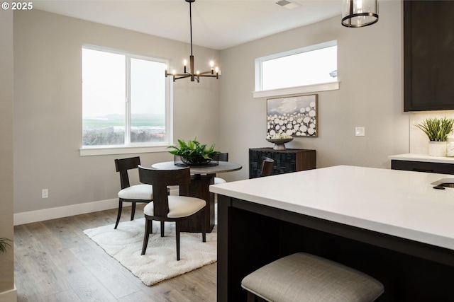 dining area featuring light wood-type flooring and an inviting chandelier