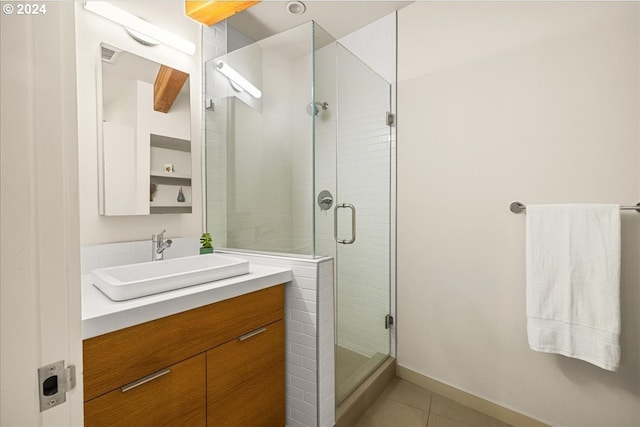 bathroom with a shower with door, tile patterned flooring, and vanity