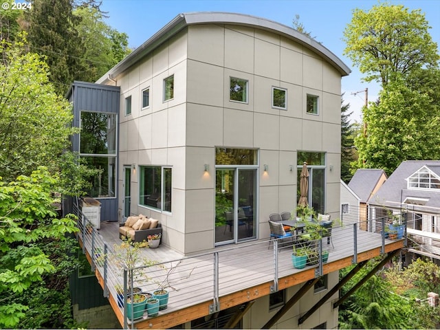 rear view of house with a wooden deck and an outdoor hangout area