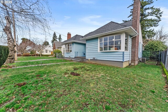 back of house featuring central AC and a lawn