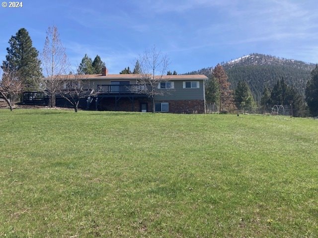 view of yard with a deck with mountain view