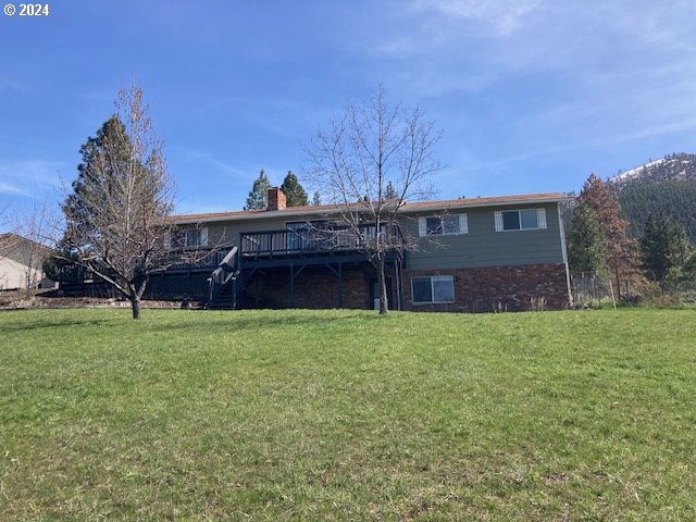 exterior space with a wooden deck and a front lawn