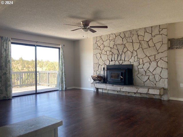 unfurnished living room with ceiling fan, dark wood-type flooring, and a textured ceiling