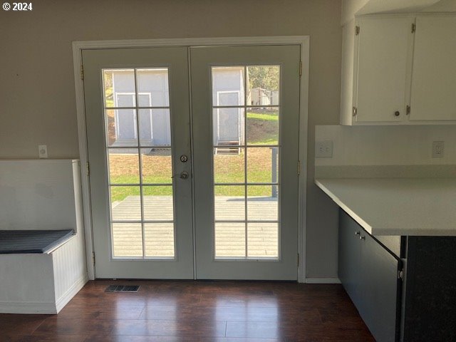 entryway featuring french doors, a healthy amount of sunlight, and dark hardwood / wood-style flooring