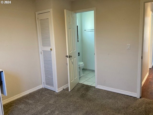 unfurnished bedroom with carpet and connected bathroom