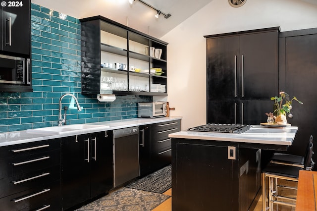 kitchen featuring sink, backsplash, appliances with stainless steel finishes, a breakfast bar, and vaulted ceiling