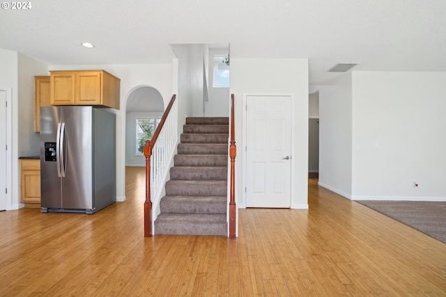 kitchen with stainless steel fridge with ice dispenser, light wood-type flooring, and light brown cabinetry