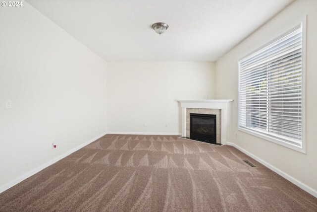 unfurnished living room featuring carpet and a fireplace