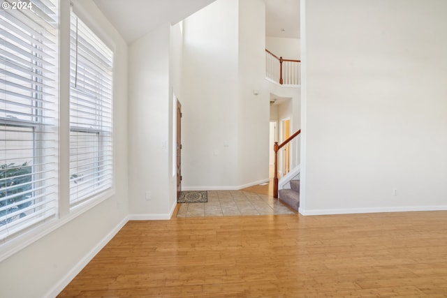 interior space with plenty of natural light, high vaulted ceiling, and light hardwood / wood-style flooring