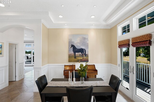 dining space featuring french doors, light tile patterned floors, ornamental molding, and a healthy amount of sunlight