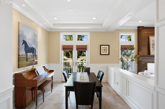 dining room featuring a raised ceiling, light tile patterned floors, recessed lighting, and wainscoting